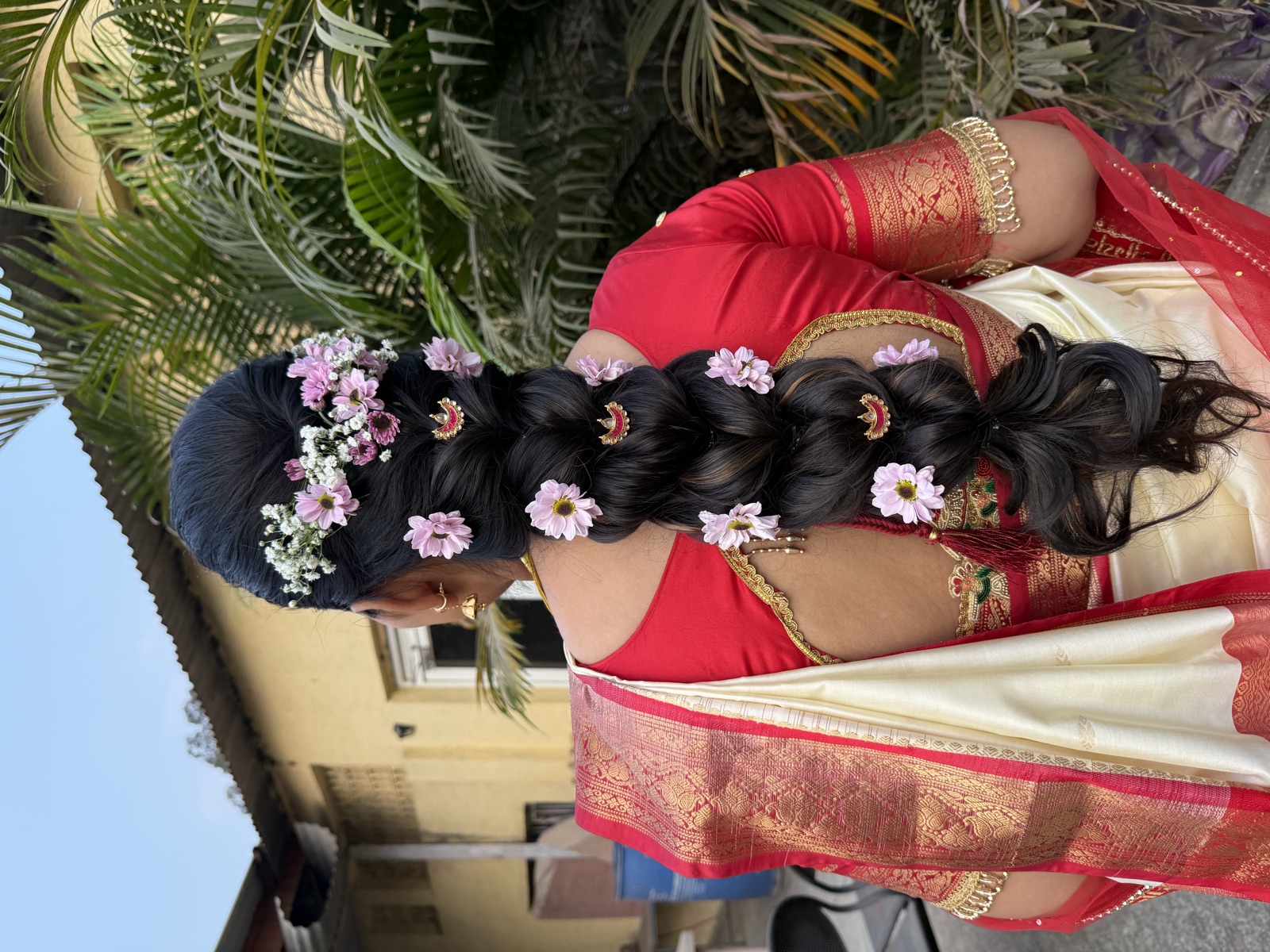 Braided hair dressed with fresh flowers, back view