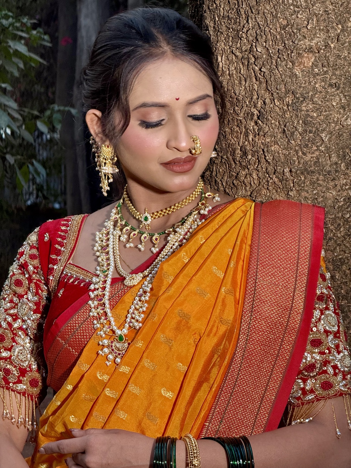 Maharashtrian bride in a mustard nauvari saree with heavy gold jewellery and nath