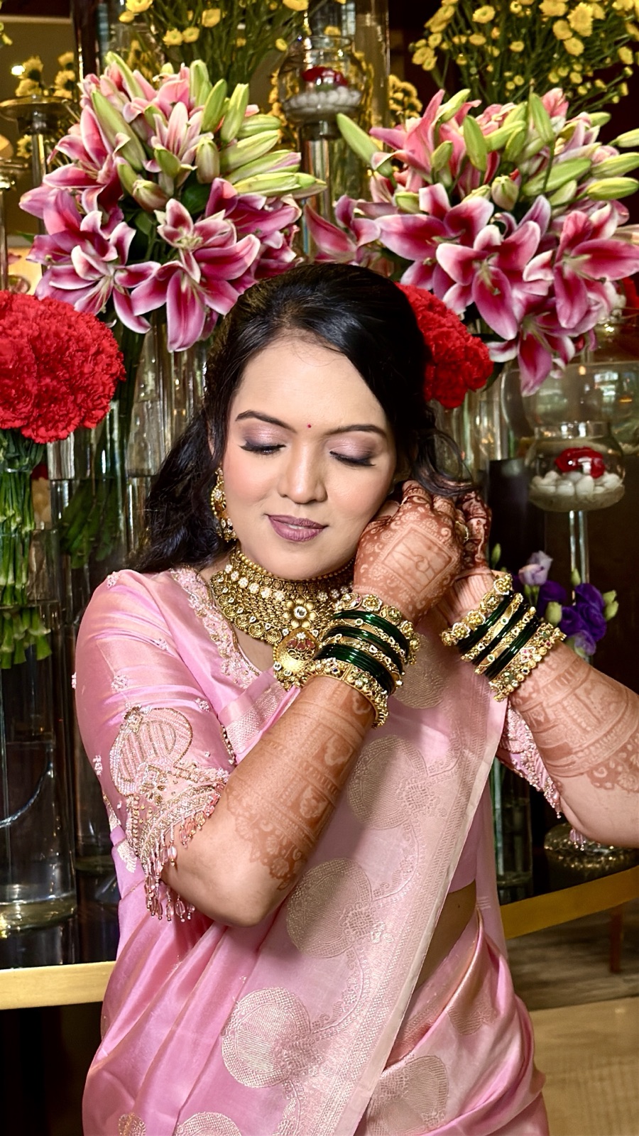 Guest look in a pink saree against a floral backdrop